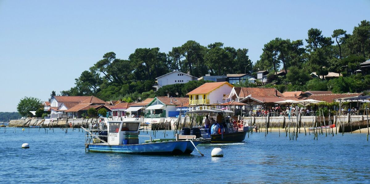 Bateaux de pêche devant les cabanes d'un village ostréicole du Bassin d'Arcachon